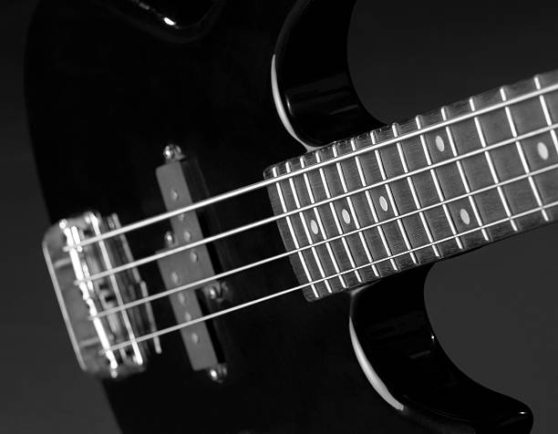 black bass guitar detail detail of a black bass guitar in dark back regler stock pictures, royalty-free photos & images