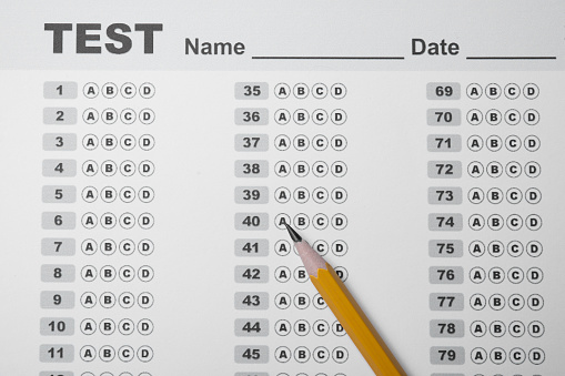 Pencil on answer sheet, top view. Student passing exam