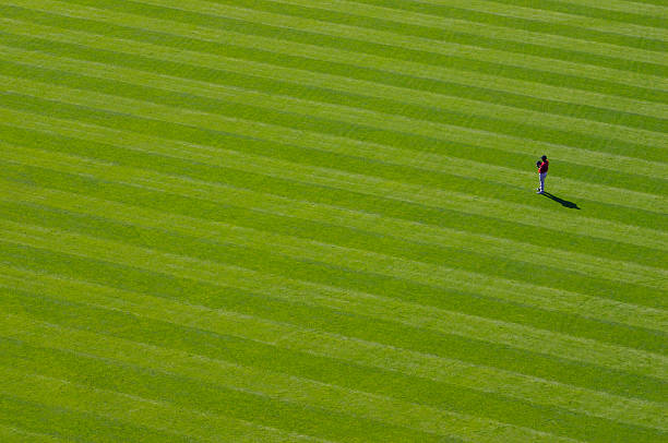 Lone outfielder A baseball player stands alone out in the outfield outfield stock pictures, royalty-free photos & images