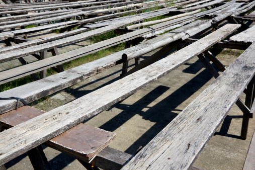 These old wooden bench are placed outdoors for drying foods under sunlight.