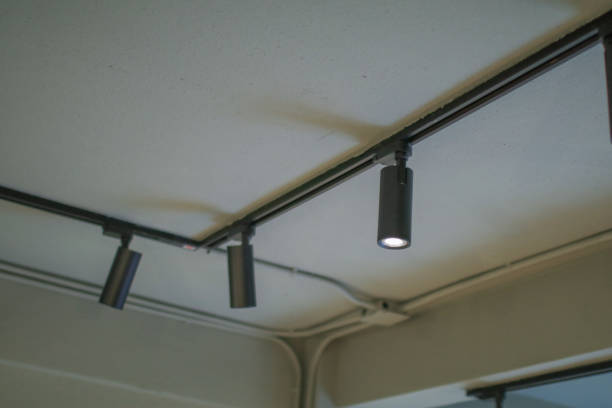 istock Illuminated black track light on ceiling. Modern LED Hanging rotating spot light. Pendant interior. 1769666409