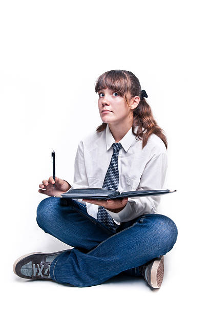 girl sitting with book and pen stock photo