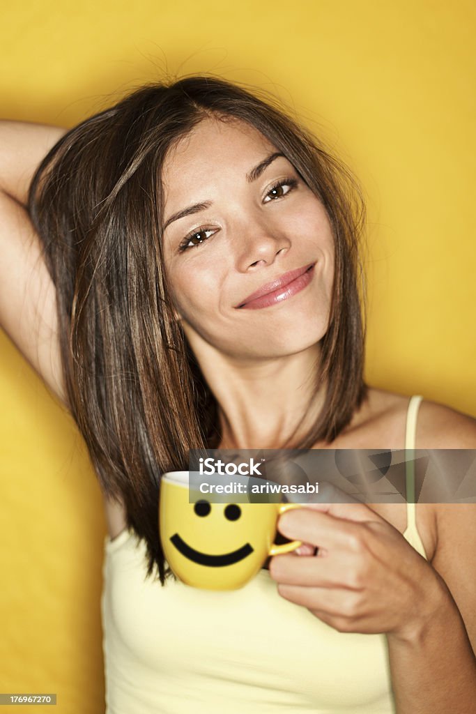 Morning Coffee Woman Tired Cute mixed-race Asian Caucasian female model waking up drinking her morning coffee on yellow background. Women Stock Photo