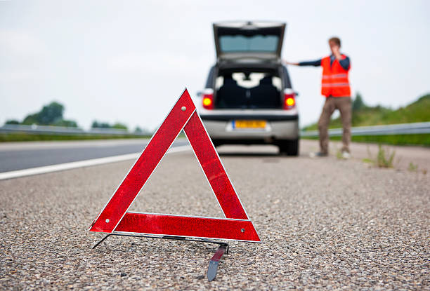 A driver uses a warning triangle while pulled over stock photo