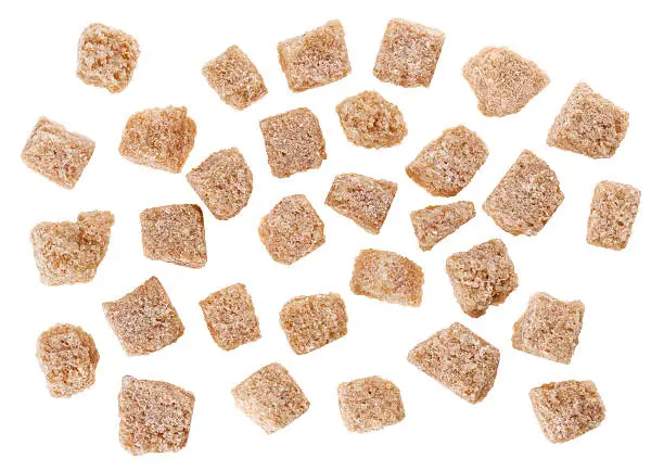 "Many brown lump cane sugar cubes isolated on white, food background"
