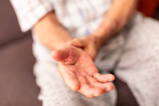 senior man tries self-massage to relieve the wrist pain - membro humano imagens e fotografias de stock