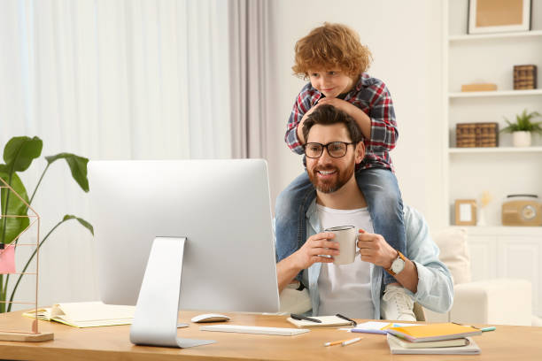 istock Man working remotely at home. Father with his child at desk 1769734106