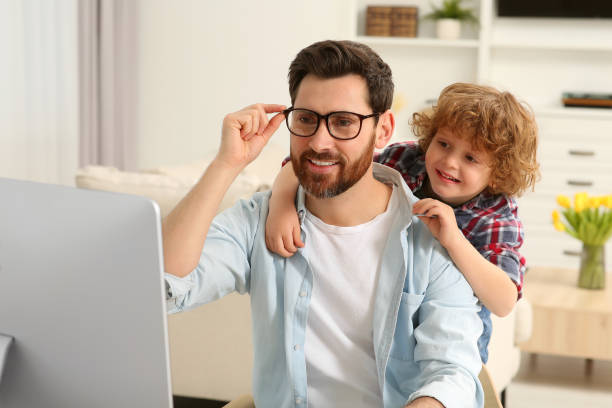 istock Man working remotely at home. Father with his child at desk 1769734107
