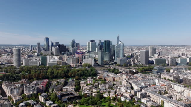 Aerial shot of modern urban borough on sunny day. Group of futuristic high rise office buildings in La Defense district. Paris, France