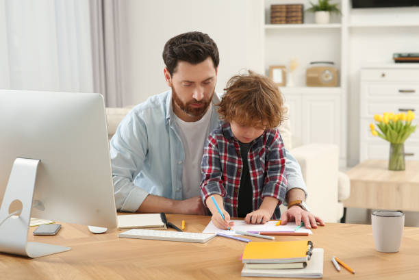 istock Father spending time with his son at desk. Taking break in remote work at home 1769749299