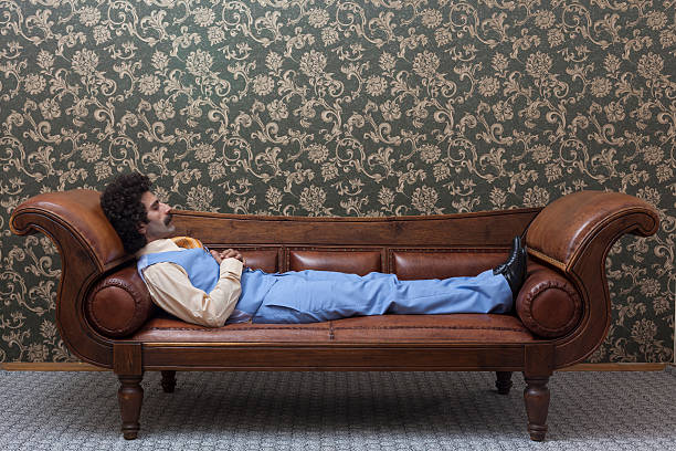 istock Mesmerized man lying down on coach in psychiatrist office 176975807