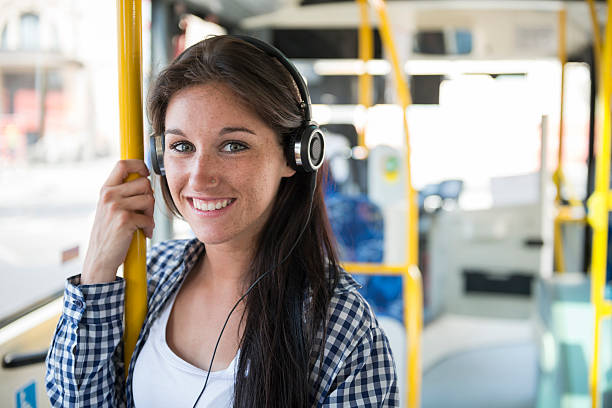 felice giovane donna con auricolare telefono sull'autobus - autobus italy foto e immagini stock