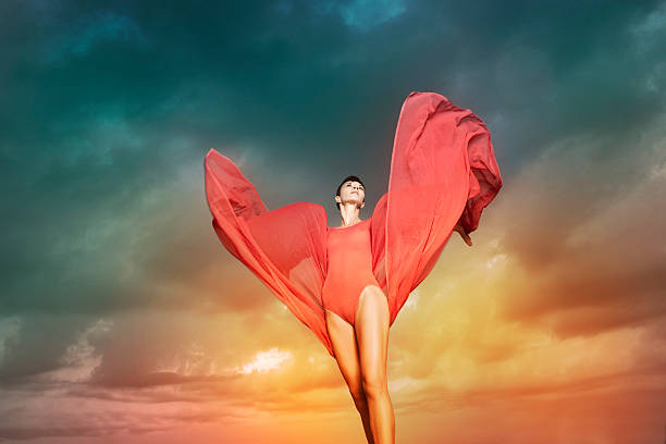 istock Beautiful woman with red chiffon in front of cloud background 176977721