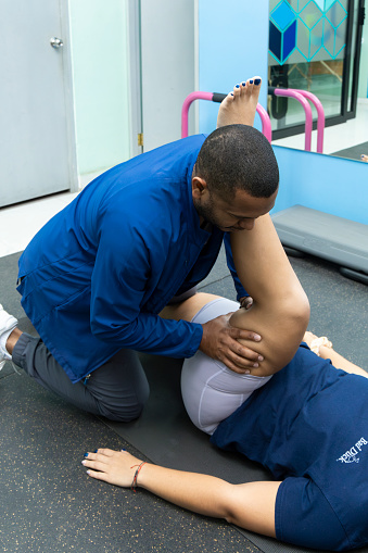 Physiotherapist helps a woman with stretching