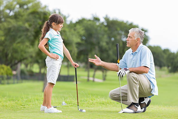 istock Golf instructor explaining game to little girl during lesson 176978683