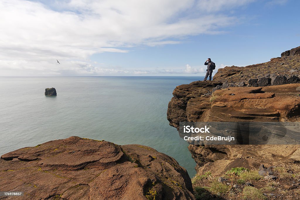 Człowiek oglądania ocean w Islandii - Zbiór zdjęć royalty-free (Chmura)