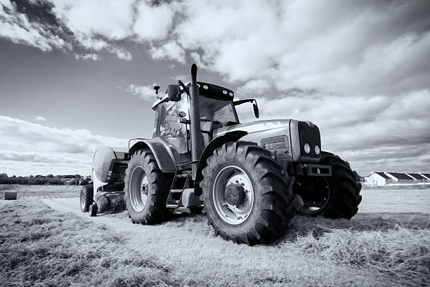 istock tractor collecting haystack in the field, panning technique 176978908