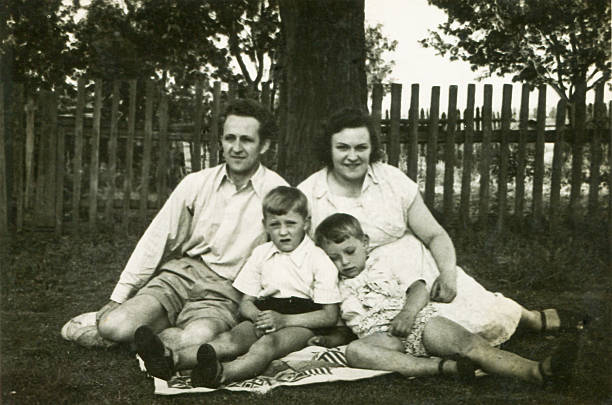 Vintage photo of parents with sons in garden stock photo