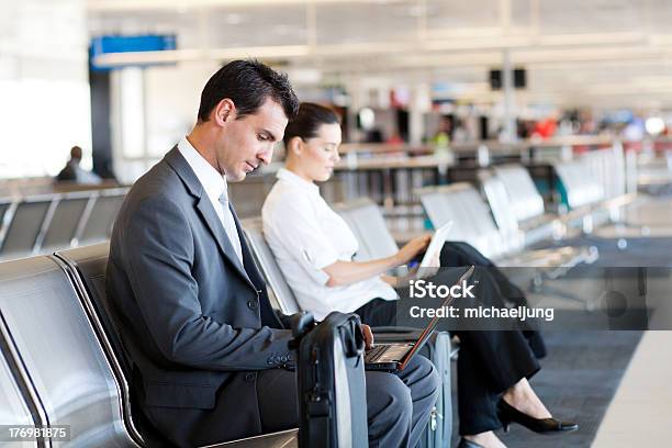 Businessman Businesswoman Using Laptop And Tablet At Airport Stock Photo - Download Image Now