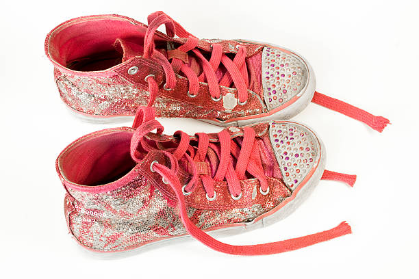 Old Kid's Sneakers "A pair of old, worn, pink high-top children's shoes covered in sequins and faux jewels isolated on white." high tops stock pictures, royalty-free photos & images