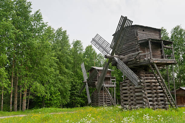 istock Two ancient wooden windmills against forest background. 176982644