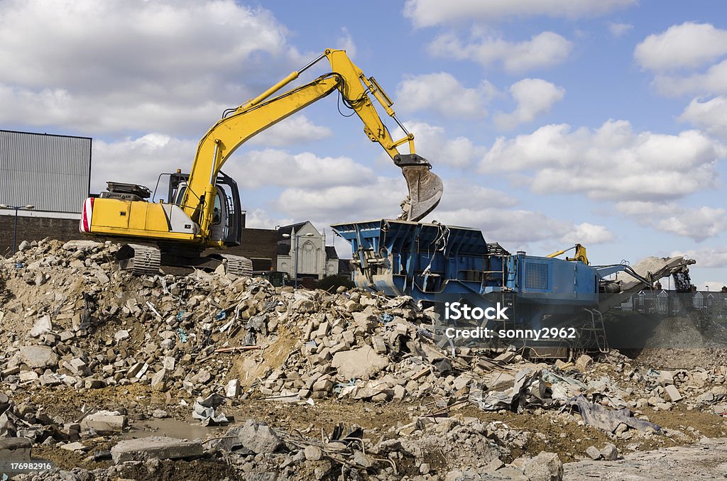 Excavator and Rubble Crusher Excavator and Rubble Crusher or Grinder on a demolition site in North East England Backhoe Stock Photo