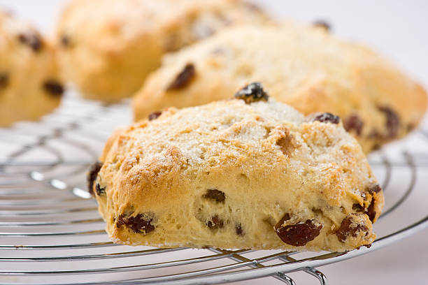 Freshly baked fruit scones on a cooling rack.