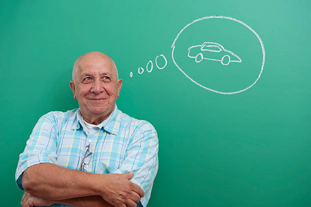 Senior man standing in front of blackboard stock photo