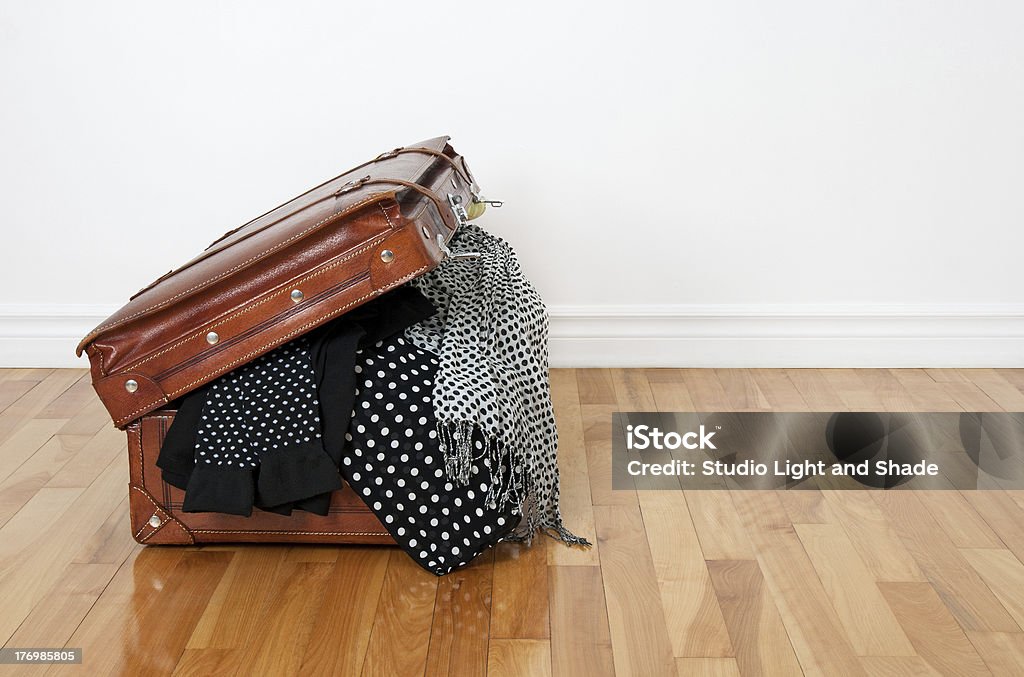 Polka dot clothing in a retro suitcase Black and white polka dot clothes in a retro leather suitcase. Business Travel Stock Photo