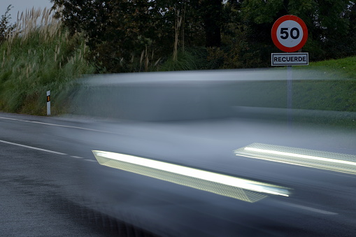 National road with speed limit. Cars crossing the road. Long exposure photography