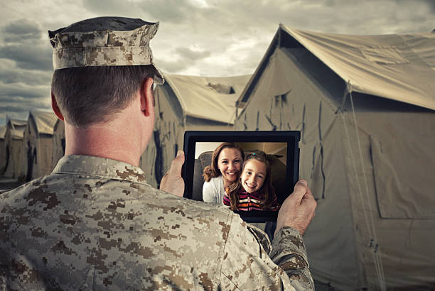 Military man video chats with family on a tablet Serviceman uses a computer tablet military deployment photos stock pictures, royalty-free photos & images