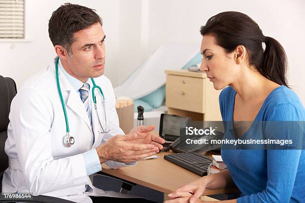 American Doctor Talking To Woman In Surgery Stock Photo - Download Image Now - Talking, Doctor, Females