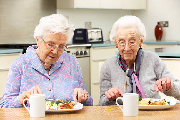 istock Senior friends enjoying meal in kitchen 176988779