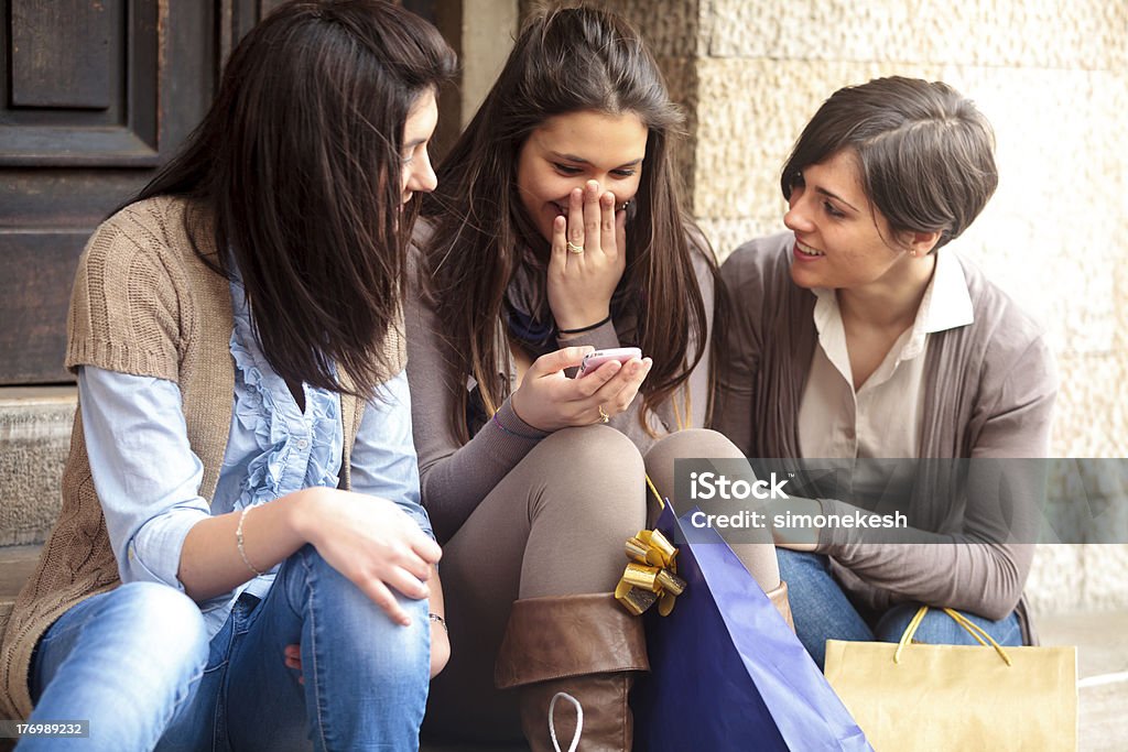 Счастливые девушки, обмен сообщениями с мобильного телефона после покупки - Стоковые фото Беспроводная технология роялти-фри