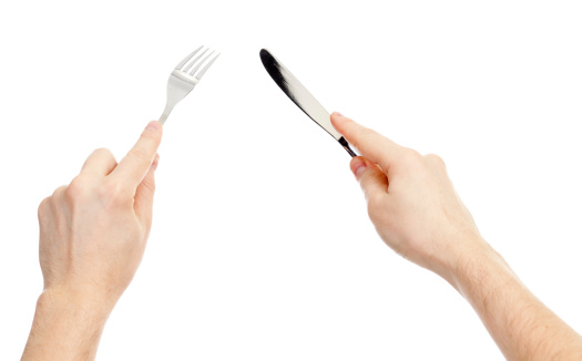 knife and fork cutlery in hands isolated