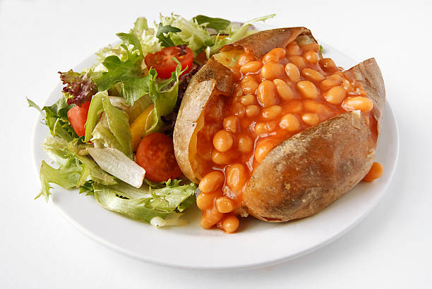 Baked Bean Jacket Potato with side salad A baked bean filled baked potato on a plate with side salad baked potato stock pictures, royalty-free photos & images