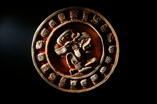 Carved Mayan calendar in dramatic light
