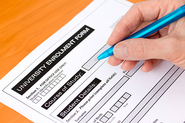 Hand Completing a University Application Form stock photo