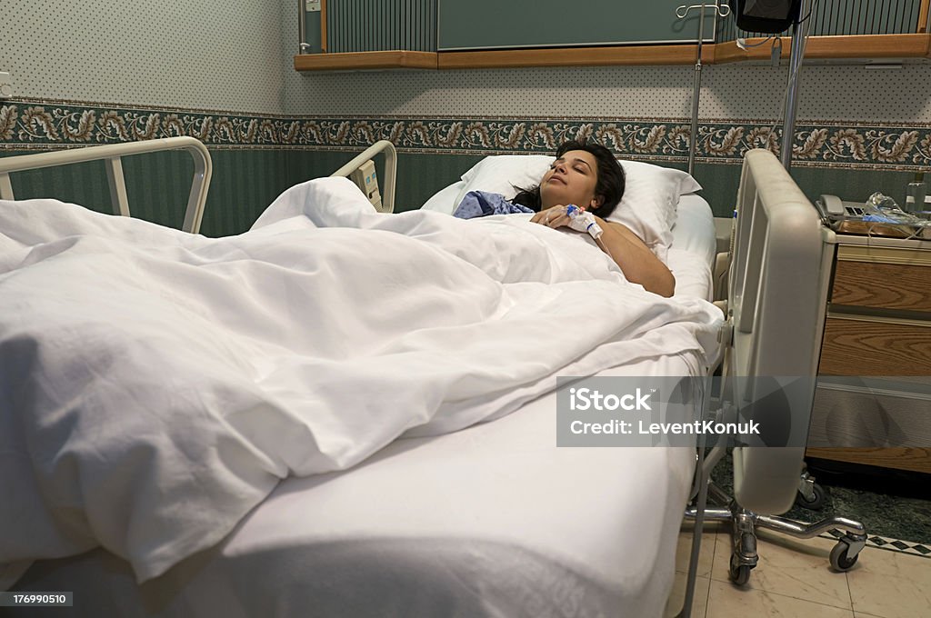 IV Drip Female patient sleeping at hospital after surgery Adult Stock Photo