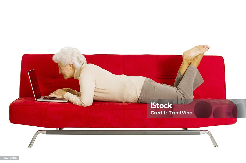 Mujer de edad avanzada en el sofá con el ordenador portátil - Foto de stock de Ordenador portátil libre de derechos