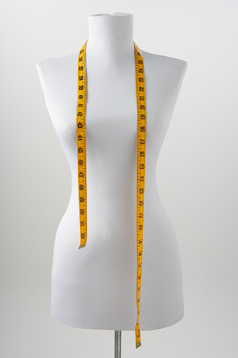 Dressmaker's mannequin with tape measure draped around neck