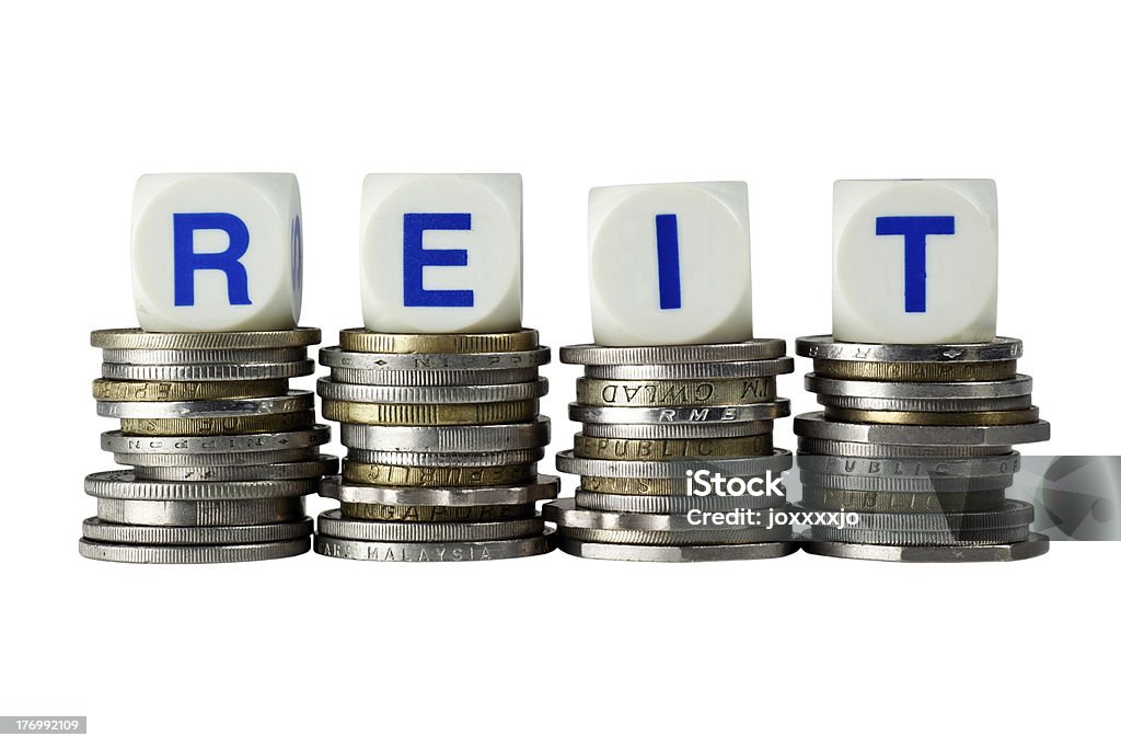 Reit Stacks of coins with the letters REIT isolated on white background Currency Stock Photo