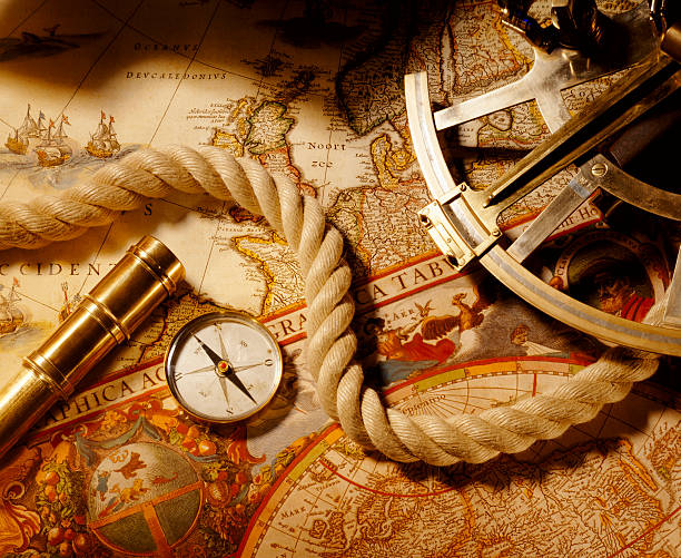 Antique compass with telescope, sextant and rope on map