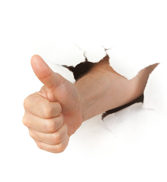 istock Hand with thumb up through a hole in paper 176993006