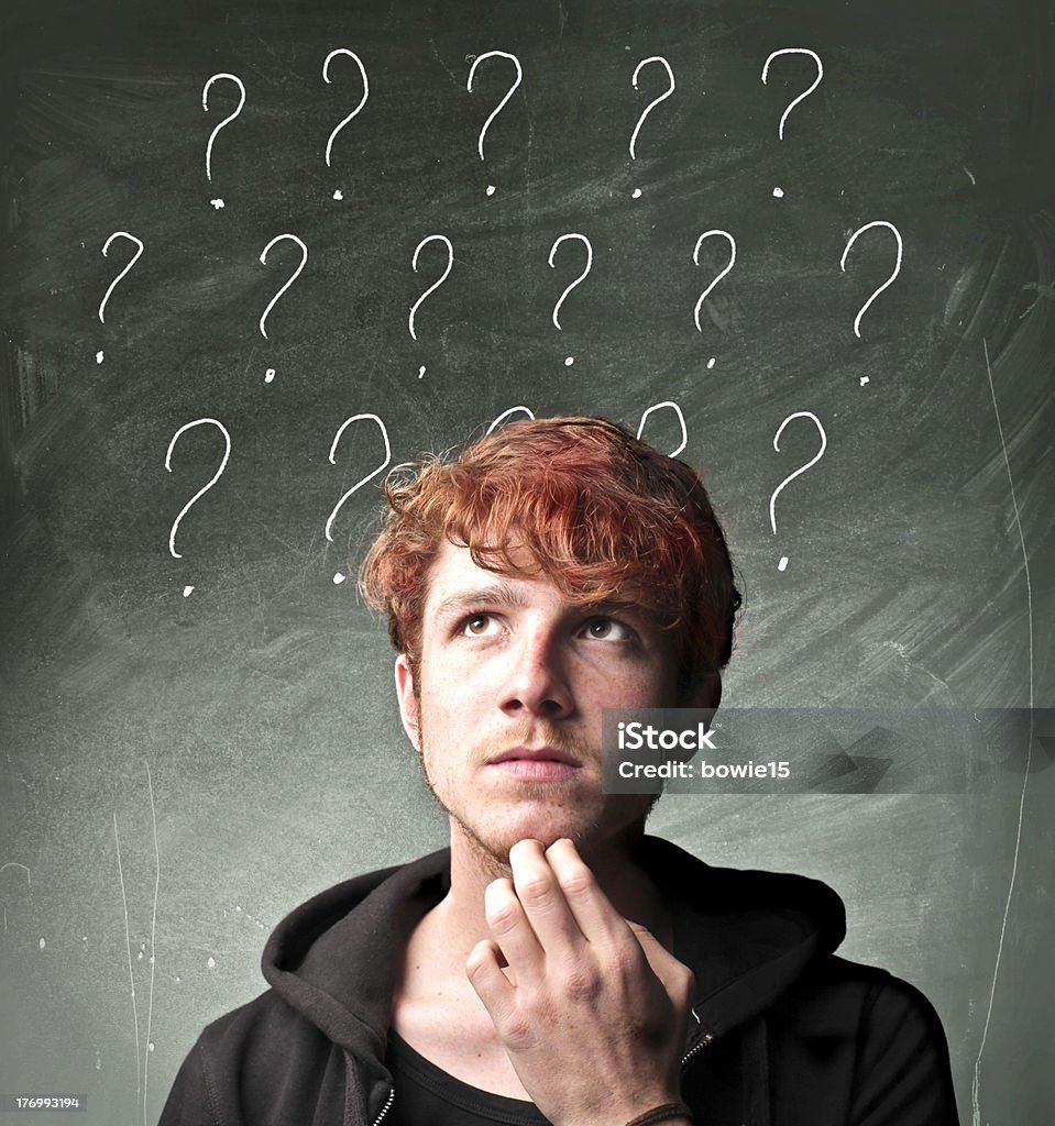 Questions Portrait of a young man with thoughtful expression and question marks over his head Adult Stock Photo