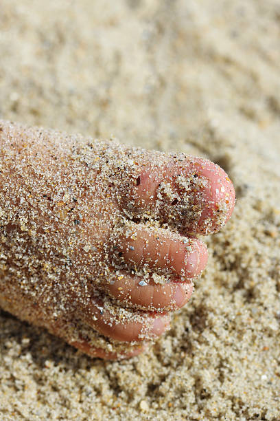 istock Children's foot in the sand 176994023