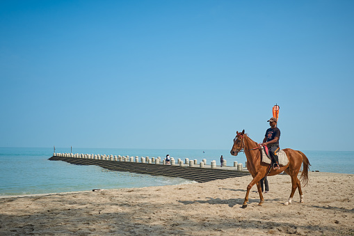 PENANG , MALAYSIA - Sep 29,2023 : Tourist riding a horse at the Batu Ferringhi beach of Penang Island