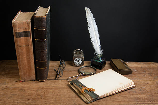 istock Quill, magnifying glass, old notebook, spectacles, books, clock on wood 176995455
