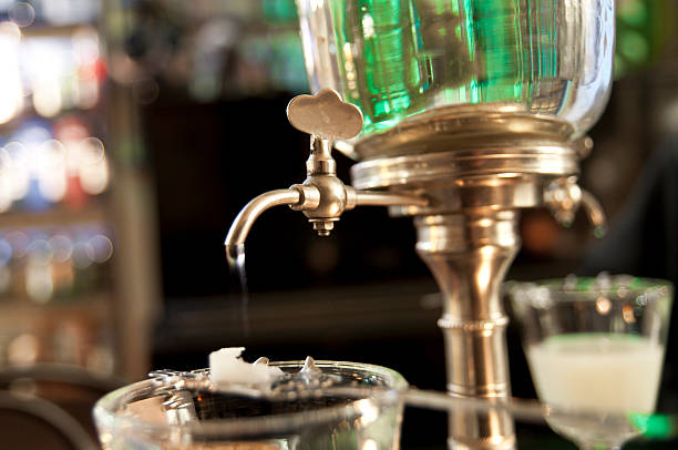 absinthe ritual "the absinthe ritual, with the water falling on a sugar cube." absinthe spoon stock pictures, royalty-free photos & images