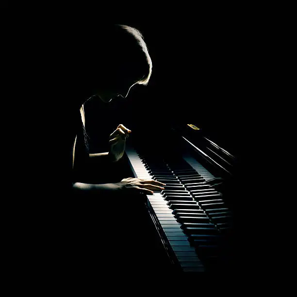 Piano playing pianist concert. Classical musician player with grand piano in darkness